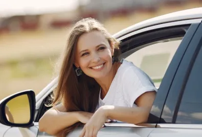 uśmiechnieta kobieta wygląda przez okno samochodu