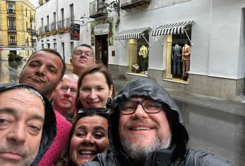 uśmiechnięci ludzie , w deszczy na ulicach Hiszpani
